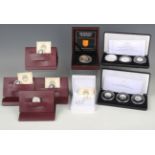 A collection of various silver commemorative coins, including a Jubilee Mint three-coin silver proof