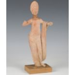 An ancient Greek Hellenistic style terracotta figure of Aphrodite, modelled semi-clad with both arms