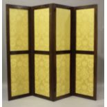 A late Victorian mahogany framed four-fold screen, inset with panels of patterned yellow damask,