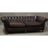 A late 20th century buttoned burgundy leather Chesterfield settee by Thomas Lloyd, height 70cm,