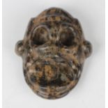 A pre-Columbian Taino style carved varicoloured hardstone human/monkey transformation mask, probably