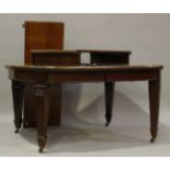A large Edwardian mahogany extending dining table, the top with two extra leaves above a fluted
