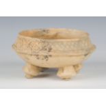 A pre-Columbian earthenware bowl, the waisted rim with incised decoration, raised on four bulbous