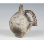 A Middle Eastern Bronze Age black ware flask, probably Iran, the ribbed spherical body incised