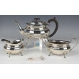 A George V silver three-piece tea set, comprising teapot, milk jug and sugar bowl, each of faceted