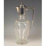 An Edwardian silver mounted glass claret jug, the clear glass ovoid body cut with arched panels