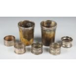 A pair of silver mounted horn beakers, height 9cm, a pair of Gorham sterling napkin rings and