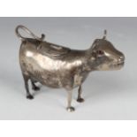 A 20th century Dutch silver cow creamer, modelled standing with tail curling up to form the