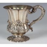 A William IV silver christening mug of lobed tapering form, decorated in relief with a band of