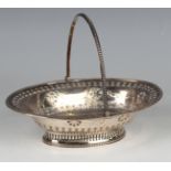 A George III silver oval bonbon basket with beaded swing handle above a pierced floral medallion and