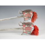 A pair of 20th century Scottish style basket-hilted sword copies with etched and fullered blades,