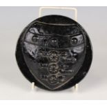 An unusual mid-19th century black glass dump style paperweight of moulded circular form and
