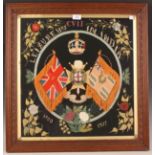 An early 20th century framed military woolwork panel depicting the crest and victories of the