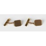 A pair of 9ct gold cufflinks, the cut cornered rectangular fronts with engine turned decoration,