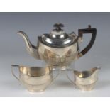 An Edwardian silver three-piece bachelor's tea set of oval half-reeded form, comprising teapot,