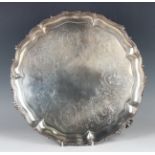A Victorian silver circular salver, the centre engraved with floral vignettes and scrolls, framed by