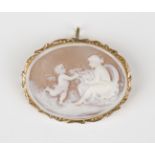 A gold mounted oval shell cameo pendant brooch, carved as a maiden with Cupid, the shaped surround