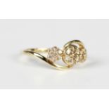 A 9ct gold and champagne diamond ring in a triple cluster twistover design, mounted with circular