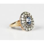 A gold, sapphire and diamond cluster ring, collet set with the oval cut sapphire within a twin