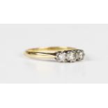 A gold and diamond three stone ring, claw set with a row of circular cut diamonds, weight 1.8g,