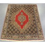 A Senneh rug, North-west Persia, mid-20th century, the red field with a shaped medallion,