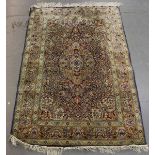 A Kashmir part silk rug, late 20th century, the blue field with a lobed medallion, supported by