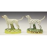 A near pair of Staffordshire pottery models of Dalmatians, late 19th century, each on a naturalistic