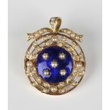 A gold, blue enamelled and seed pearl circular pendant brooch, circa 1910, mounted with five seed