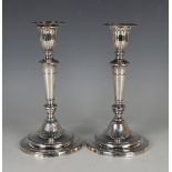 A pair of George III silver candlesticks, each with gadrooned detachable nozzle above a reeded