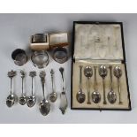 A small group of silver items, including a set of six coffee spoons, cased, and four napkin rings,