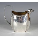 A George III silver cream jug of swollen rectangular form with canted corners, the reeded rim