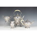 An Edwardian silver four-piece tea set, each chase engraved with crest and motto with scrolling rose