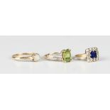 A 9ct gold ring, claw set with a cut cornered rectangular step cut peridot between diamond set