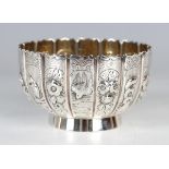 A Victorian silver circular bowl, the lobed sides decorated in relief with flowers, birds, fishes,