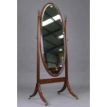 An early 20th century mahogany framed cheval mirror, the oval bevelled glass within a chequer inlaid