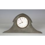 An early 20th century Arts and Crafts pewter cased mantel clock, the arched case back stamped '