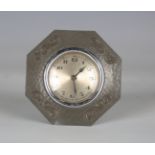 A Liberty & Co 'Tudric' pewter framed octagonal boudoir timepiece with silvered dial and foliate