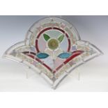 A pair of late Victorian stained and leaded glass fan shaped panels, each worked with a central