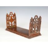 A late 19th century Gothic Revival mahogany extending bookrack of pierced and carved form, closed