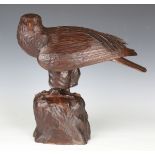 A 20th century carved oak model of an eagle, perched on a rocky outcrop, height 42cm.Buyer’s Premium
