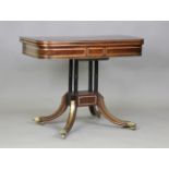 A Regency mahogany and brass inlaid fold-over card table, the hinged top above four turned columns