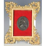 A patinated bronze oval plaque, cast in relief with a profile portrait of Louis XIV, bearing