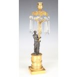 A late 19th century Regency style gilt and brown patinated bronze figural candlestick, hung with