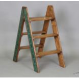 A set of late 20th century walnut folding steps, the sides sign-written with champagne