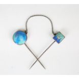 An early 20th century Arts and Crafts white metal and enamelled double stickpin, one inlaid with a