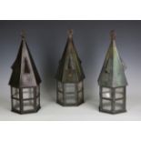 A set of three Arts and Crafts patinated copper hall lanterns with vented hoods and hexagonal glazed