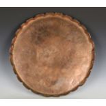 A late 19th/early 20th century Arts and Crafts copper circular tray, the front incised with an