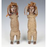 A pair of Bocio fetish figures, Benin, the carved wooden bodies bound in string and applied with