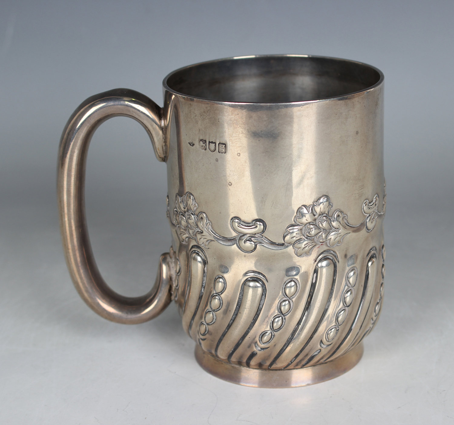 An Edwardian silver tankard of cylindrical form with loop handle and half spiral reeded and beaded