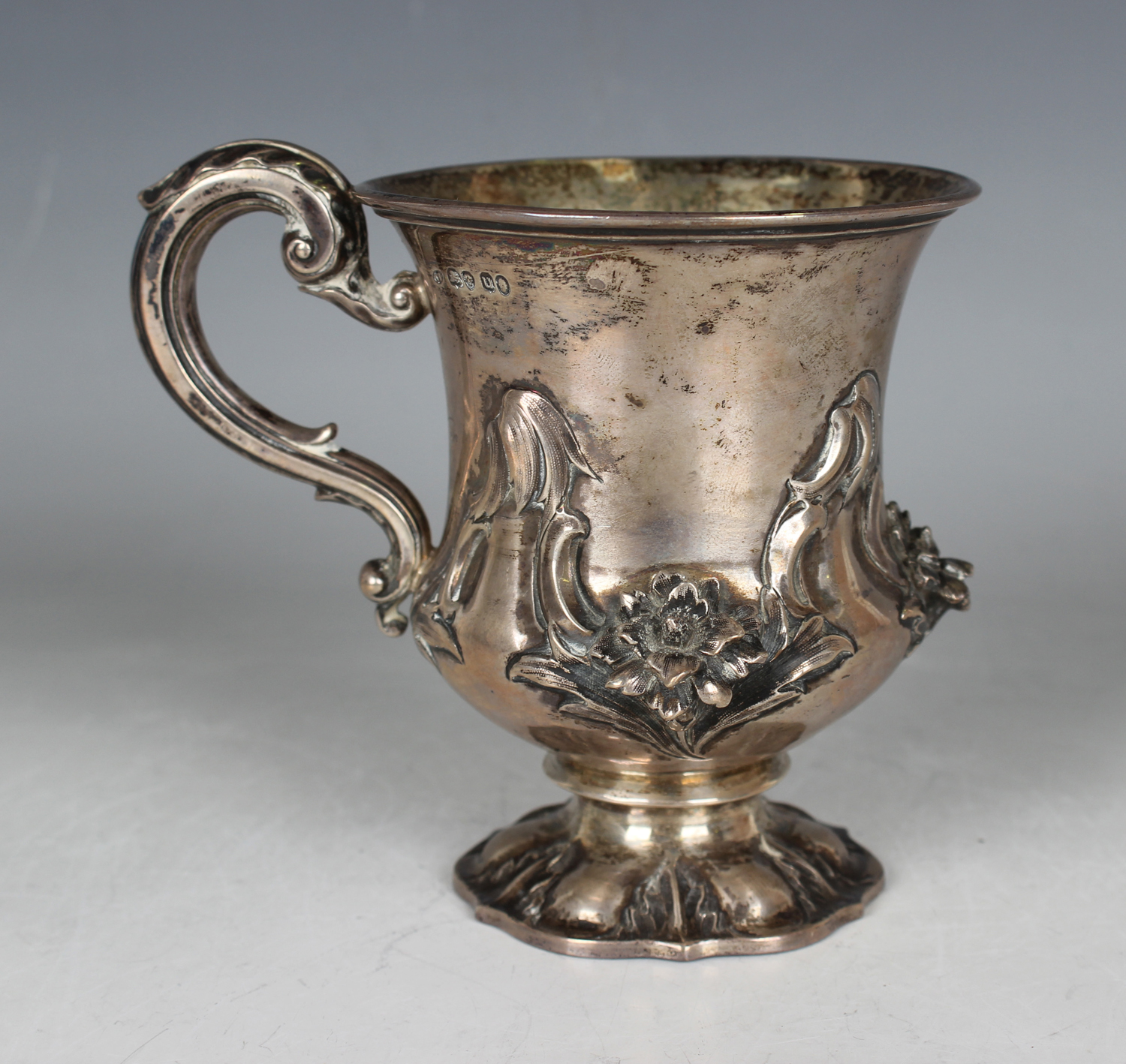 A William IV silver christening tankard of urn form, decorated in relief with a band of flowers